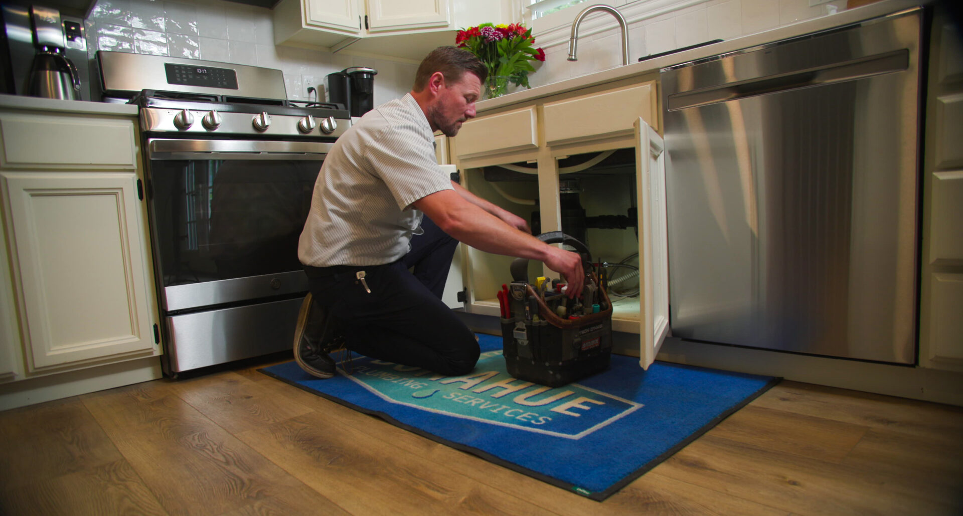 Donahue Plumbing technician at a customers home fixing a leaking sink